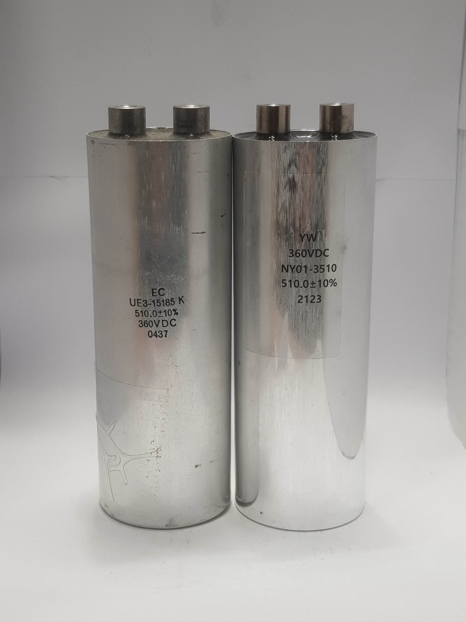 Original EC UE3-15185 K capacitor on the left and YW NY01-3510 replacement capacitor on the right
